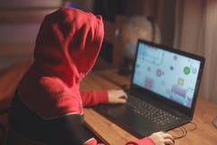 Маленький ребенк gamer в клобуке играя массовую предназначенную для многих игроков игру онлайн на ноутбуке стоковая фотография rf Маленький ребенк gamer в клобуке играя массовую предназначенную для многих игроков игру онлайн на ноутбуке стоковая фотография rf