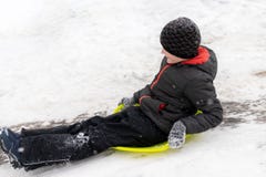 Мальчик 7 лет едет скольжение, вниз с холма на зеленом скелетоне льда Концепция деятельностей при, воссоздания и детей зимы стоковые фотографии rf Мальчик 7 лет едет скольжение, вниз с холма на зеленом скелетоне льда Концепция деятельностей при, воссоздания и детей зимы стоковые фотографии rf