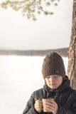Мальчик с горячим напитком зимы на открытом воздухе стоковая фотография Мальчик с горячим напитком зимы на открытом воздухе стоковая фотография