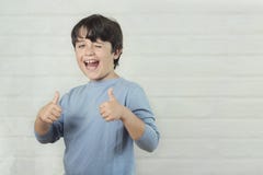Мальчик усмехаясь показывающ большие пальцы руки вверх стоковые изображения rf Мальчик усмехаясь показывающ большие пальцы руки вверх стоковые изображения rf