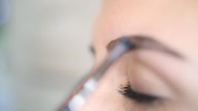 Мастер Cosmetoligist макияж черноты Foing на бровях для клиента молодой женщины 4K очарование M.U.A., Slowmotion сток-видео Мастер Cosmetoligist макияж черноты Foing на бровях для клиента молодой женщины 4K очарование M.U.A., Slowmotion сток-видео