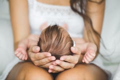 Мать, держа голову его newborn сына стоковая фотография Мать, держа голову его newborn сына стоковая фотография