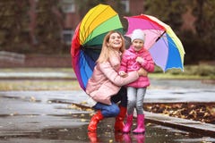 Мать и дочь с зонтиками принимая прогулку осени в городе стоковые фотографии rf Мать и дочь с зонтиками принимая прогулку осени в городе стоковые фотографии rf