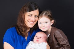 Мать и милая дочь старшей сестры с новым newborn сыном младенца стоковые фотографии rf Мать и милая дочь старшей сестры с новым newborn сыном младенца стоковые фотографии rf