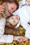 Мать и дочь лежа на листьях осени стоковое фото Мать и дочь лежа на листьях осени стоковое фото