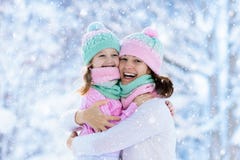 Мать и ребенок в связанных шляпах зимы в снеге стоковое фото rf Мать и ребенок в связанных шляпах зимы в снеге стоковое фото rf