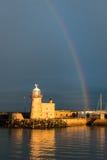 Маяк на гавани Howth в графстве Дублине искупал в солнечном свете под радугой перед бурным небом стоковое фото Маяк на гавани Howth в графстве Дублине искупал в солнечном свете под радугой перед бурным небом стоковое фото