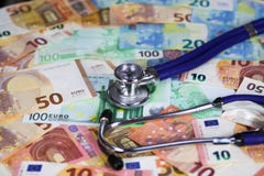 Медицинская стоить концепция - стетоскоп на бумажных деньгах денег бумаги евро стоковое фото rf Медицинская стоить концепция - стетоскоп на бумажных деньгах денег бумаги евро стоковое фото rf