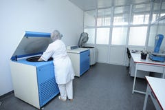 Медсестра устанавливая контейнеры с кровью в центрифуге стоковая фотография Медсестра устанавливая контейнеры с кровью в центрифуге стоковая фотография