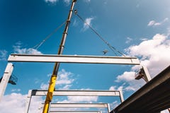 Место индустриального строительства при кран башни работая с полуфабрикат лучами и штендерами стоковое фото Место индустриального строительства при кран башни работая с полуфабрикат лучами и штендерами стоковое фото