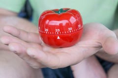 Механический красный набор таймера кухни томата до 25, придержанный одной открытой рукой стоковые изображения Механический красный набор таймера кухни томата до 25, придержанный одной открытой рукой стоковые изображения
