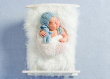 Мечтательные newborn сны игрушки удерживания мальчика стоковая фотография rf Мечтательные newborn сны игрушки удерживания мальчика стоковая фотография rf