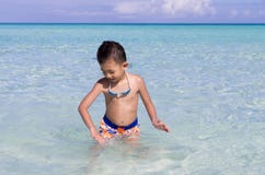 Милый маленький азиатский мальчик играя с в голубой водой бирюзы стоковые изображения Милый маленький азиатский мальчик играя с в голубой водой бирюзы стоковые изображения
