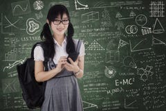 Милый студент используя мобильный телефон для отправки СМС стоковое изображение Милый студент используя мобильный телефон для отправки СМС стоковое изображение