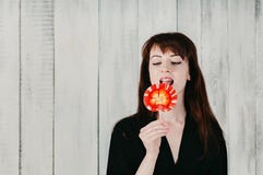 Милая девушка брюнет в черном платье, лижа красный леденец на палочке стоковые изображения rf Милая девушка брюнет в черном платье, лижа красный леденец на палочке стоковые изображения rf