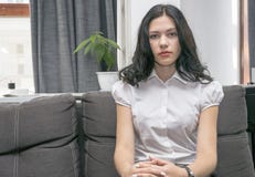 Милая девушка сидя на сером кресле, имеющ остатки стоковые фото Милая девушка сидя на сером кресле, имеющ остатки стоковые фото