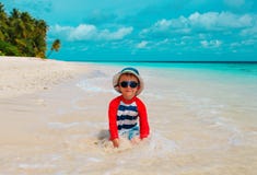Милая игра мальчика с водой и песком на пляже стоковая фотография rf Милая игра мальчика с водой и песком на пляже стоковая фотография rf