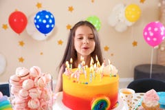Милая маленькая девочка дуя вне свечи на ее именнином пироге стоковая фотография rf Милая маленькая девочка дуя вне свечи на ее именнином пироге стоковая фотография rf
