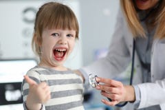 Милая маленькая девочка на офисе доктора показывая признательность уважения и одобрить для качественного сервиса с большим пальце стоковое изображение Милая маленькая девочка на офисе доктора показывая признательность уважения и одобрить для качественного сервиса с большим пальце стоковое изображение