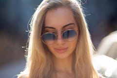 Милая молодая модель со стеклами длинных волос нося, представляя на улице в солнечном дне стоковое изображение Милая молодая модель со стеклами длинных волос нося, представляя на улице в солнечном дне стоковое изображение