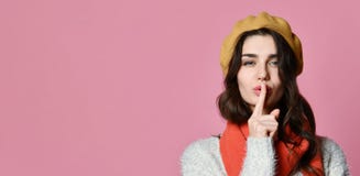 Милая очаровательная молодая женщина имея секретный палец удерживания промежутка времени на губах и показывая знак безмолвия стоковые изображения Милая очаровательная молодая женщина имея секретный палец удерживания промежутка времени на губах и показывая знак безмолвия стоковые изображения