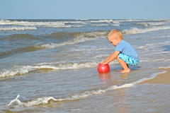 Милый мальчик играет с шариком на seashore стоковые фото Милый мальчик играет с шариком на seashore стоковые фото