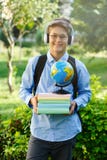 Милый, молодой мальчик в круглых стеклах и голубая рубашка держат книги с его руками в парке Читающ и учащ образование концепции стоковое фото rf Милый, молодой мальчик в круглых стеклах и голубая рубашка держат книги с его руками в парке Читающ и учащ образование концепции стоковое фото rf