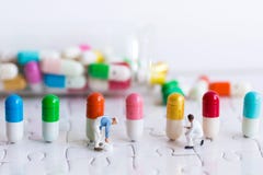 Миниатюрные люди: Работник красит цвет на целебных капсулах Польза изображения для механизмов продукции лекарства стоковое изображение Миниатюрные люди: Работник красит цвет на целебных капсулах Польза изображения для механизмов продукции лекарства стоковое изображение