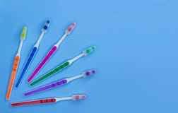 Много зубные щетки лежат на пастельной голубой предпосылке с космосом экземпляра E стоковая фотография rf Много зубные щетки лежат на пастельной голубой предпосылке с космосом экземпляра E стоковая фотография rf