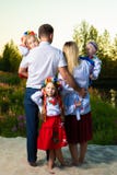 Многодетная семья в этнических украинских костюмах сидит на луге, концепции многодетной семьи задний взгляд стоковые фотографии rf Многодетная семья в этнических украинских костюмах сидит на луге, концепции многодетной семьи задний взгляд стоковые фотографии rf
