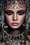 Модель красоты высокой моды с металлическим headwear и темным составом и голубые глазы на черной предпосылке Стоковая Фотография RF Модель красоты высокой моды с металлическим headwear и темным составом и голубые глазы на черной предпосылке Стоковая Фотография RF