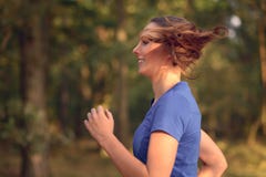 Молодая женщина jogging в сельской местности Стоковые Изображения Молодая женщина jogging в сельской местности Стоковые Изображения
