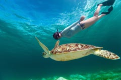 Молодая женщина snorkeling с морской черепахой стоковые изображения rf Молодая женщина snorkeling с морской черепахой стоковые изображения rf