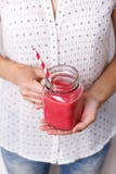 Молодая женщина держит питье вытрезвителя, smoothie в стеклянном опарнике Стоковая Фотография RF Молодая женщина держит питье вытрезвителя, smoothie в стеклянном опарнике Стоковая Фотография RF