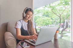 Молодая женщина используя компьтер-книжку, listenning к музыке стоковые изображения Молодая женщина используя компьтер-книжку, listenning к музыке стоковые изображения