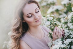 Молодая женщина с длинными красивыми волосами в шифоновом платье представляя с садом lilacin с белыми цветками стоковые изображения Молодая женщина с длинными красивыми волосами в шифоновом платье представляя с садом lilacin с белыми цветками стоковые изображения