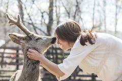 Молодая красивая женщина обнимая животных оленей КОСУЛЬ в солнечности стоковые фотографии rf Молодая красивая женщина обнимая животных оленей КОСУЛЬ в солнечности стоковые фотографии rf