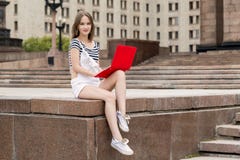 Молодая красивая женщина при компьтер-книжка сидя на лестницах около университета стоковые изображения Молодая красивая женщина при компьтер-книжка сидя на лестницах около университета стоковые изображения