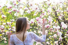 Молодая милая девушка ослабляет в красивом саде Фантастические розовые магнолии Стоковая Фотография Молодая милая девушка ослабляет в красивом саде Фантастические розовые магнолии Стоковая Фотография