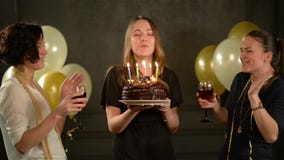 Молодая милая женщина делает желание и дует вне свечи на шоколадном торте, 2 усмехаясь дамы Clinking стекла акции видеоматериалы Молодая милая женщина делает желание и дует вне свечи на шоколадном торте, 2 усмехаясь дамы Clinking стекла акции видеоматериалы