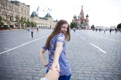 Молодая счастливая девушка вытягивает руку парней на красной площади в Москве стоковые изображения Молодая счастливая девушка вытягивает руку парней на красной площади в Москве стоковые изображения
