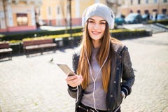Молодая счастливая женщина, слушая музыка и потеха иметь на улице внешней стоковая фотография rf Молодая счастливая женщина, слушая музыка и потеха иметь на улице внешней стоковая фотография rf