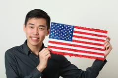 Молодой азиатский студент показывая национальный флаг США стоковое изображение rf Молодой азиатский студент показывая национальный флаг США стоковое изображение rf