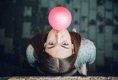 Молодой девочка-подросток дуя розовая жевательная резинка стоковые изображения Молодой девочка-подросток дуя розовая жевательная резинка стоковые изображения