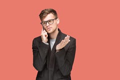 Молодой кавказский бизнесмен на красной предпосылке говоря на сотовом телефоне Стоковые Фото Молодой кавказский бизнесмен на красной предпосылке говоря на сотовом телефоне Стоковые Фото