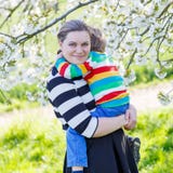 Молодой мальчик мамы и маленького ребенка в зацветая саде Стоковые Фотографии RF Молодой мальчик мамы и маленького ребенка в зацветая саде Стоковые Фотографии RF
