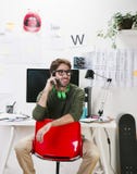 Молодой творческий дизайнерский человек на телефоне работая на офисе. стоковое изображение rf Молодой творческий дизайнерский человек на телефоне работая на офисе. стоковое изображение rf