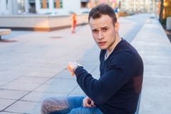 Молодой человек смотрит его вахту проверяя время. стоковое фото rf Молодой человек смотрит его вахту проверяя время. стоковое фото rf