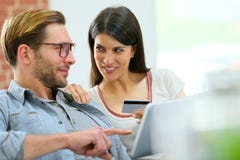 Молодые пары дома ходя по магазинам на интернете с таблеткой стоковое изображение Молодые пары дома ходя по магазинам на интернете с таблеткой стоковое изображение