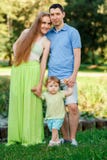Молодые родители с маленькой дочерью в парке стоковое фото Молодые родители с маленькой дочерью в парке стоковое фото